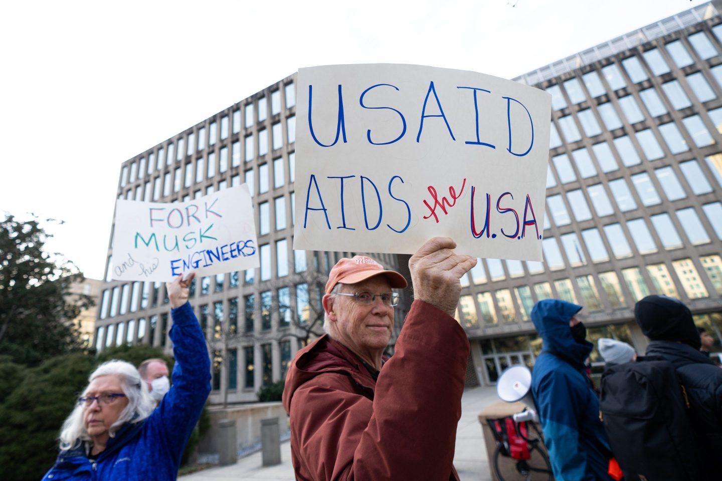 Activists hold signs during the Fork Off Coalition protest to "stop the Musk coup"