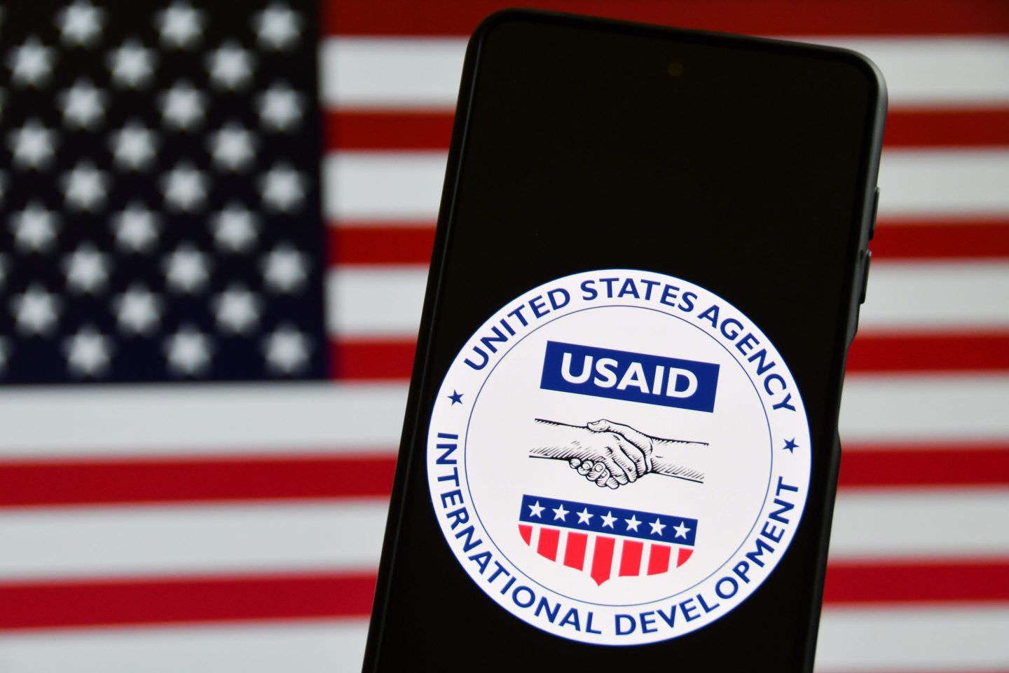The United States Agency for International Development (USAID) emblem is screened on a mobile phone