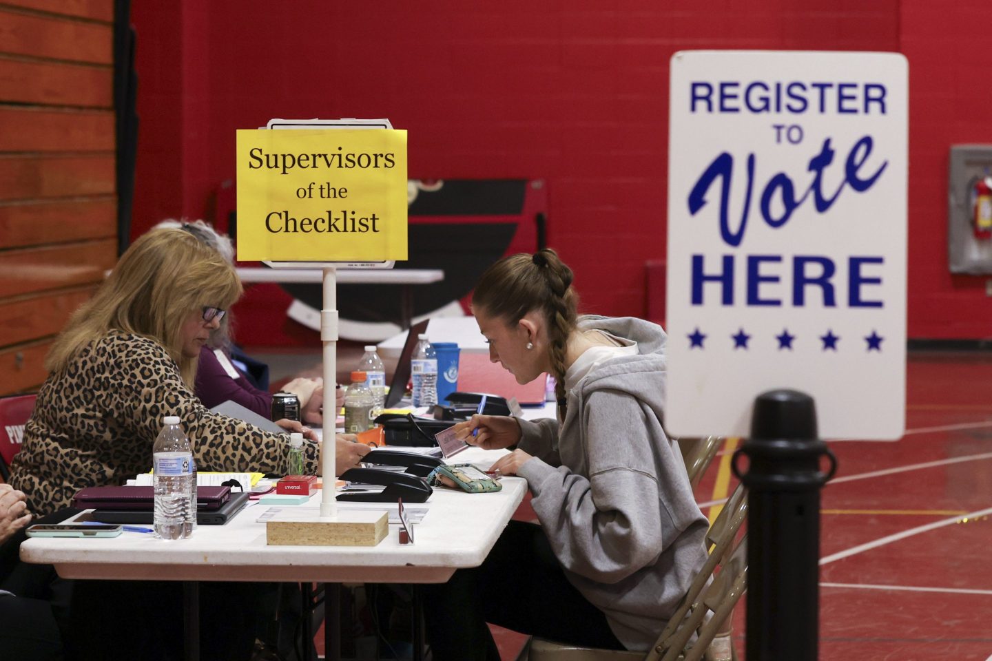 Supervisor of the Checklist for the State of New Hampshire Leslie Dombroski, left, registers Elise Collins, 18, to vote in Derry, N.H., on March 11, 2025.