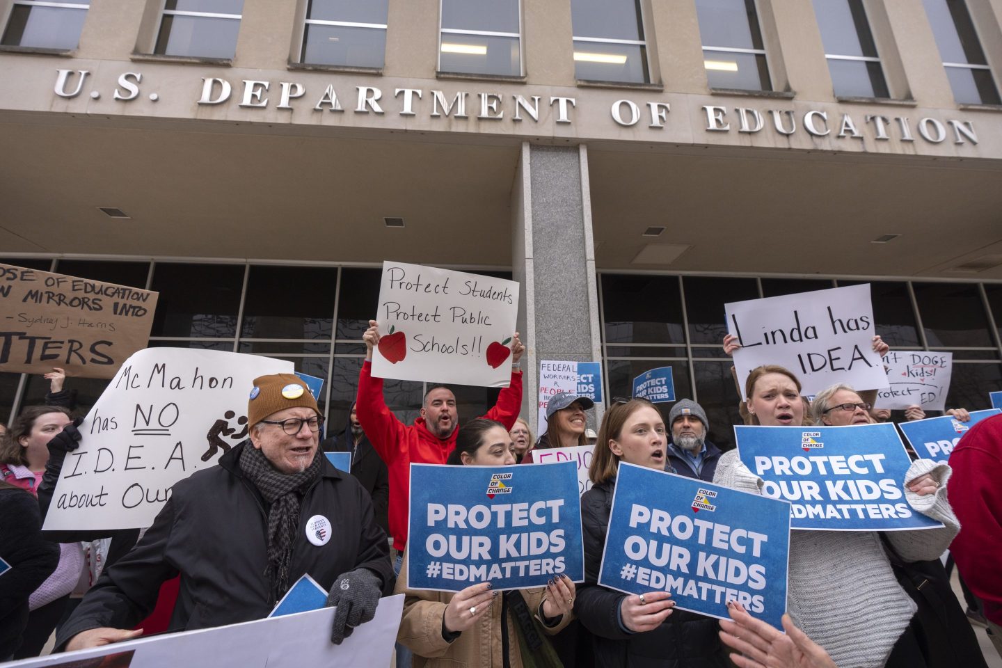 Protestors gather during a demonstration at the headquarters of the Department of Education on Friday.