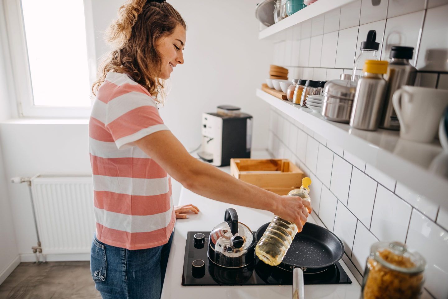 Young woman making breakfast in the kitchen at home
