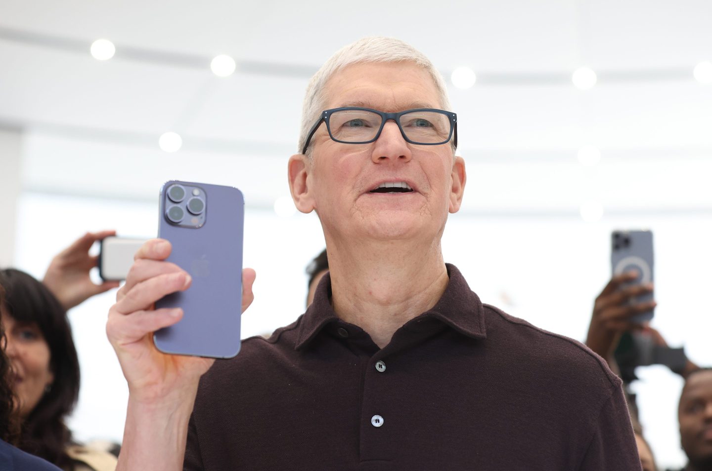 Apple CEO Tim Cook looks at a new iPhone 14 Pro during a special event in 2022.