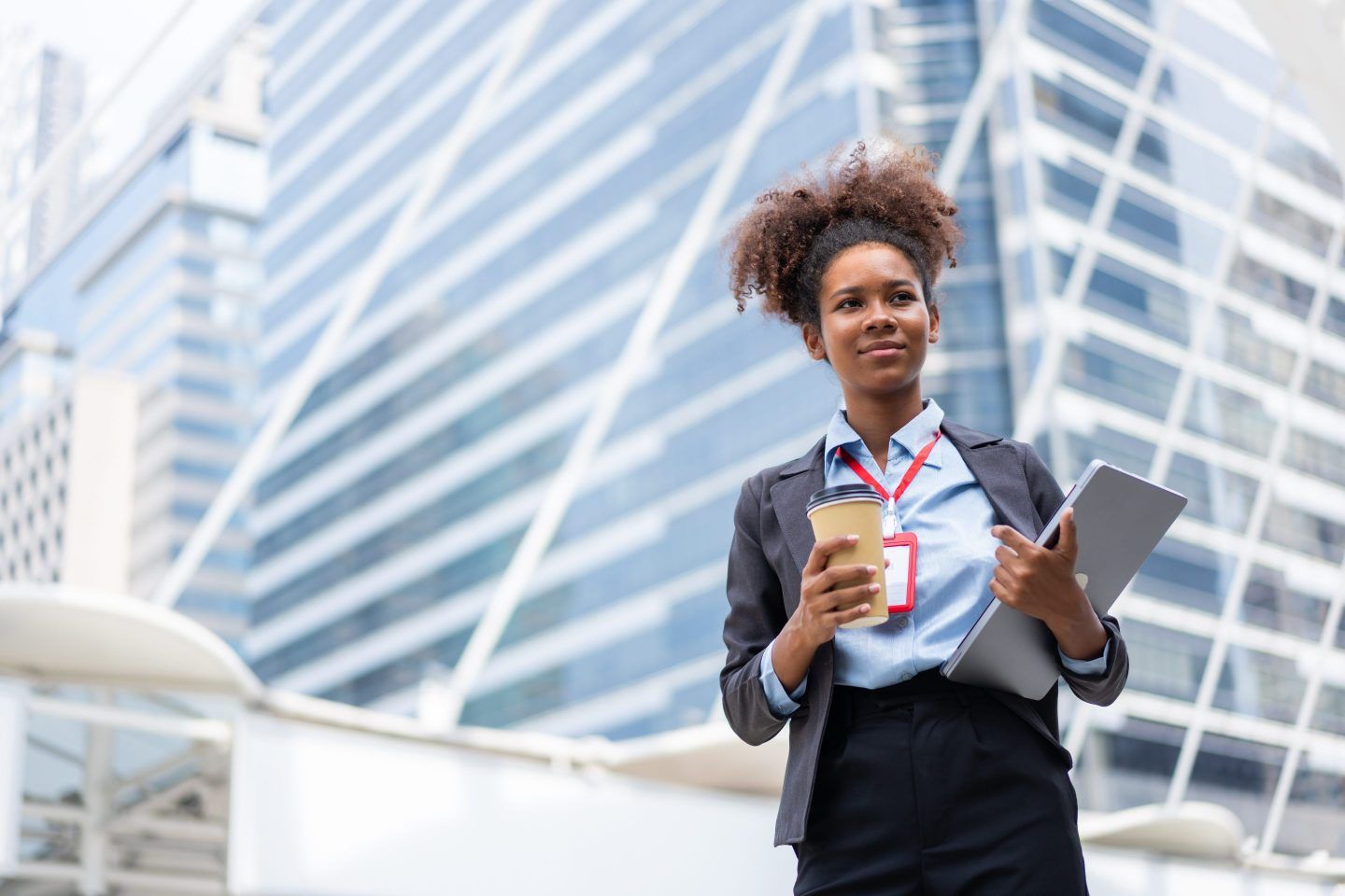 Photo of a businesswoman walking near office buildings