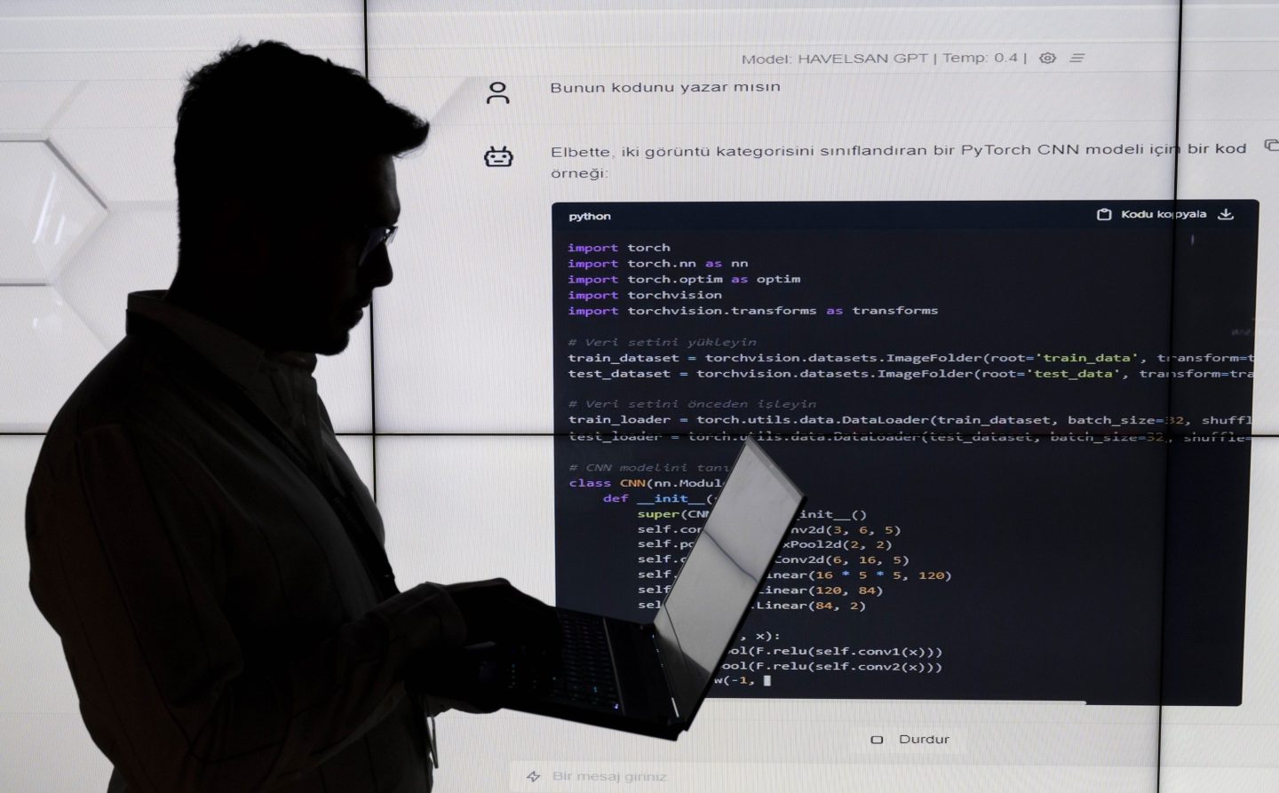 Silhouette of a man with a laptop with code behind him
