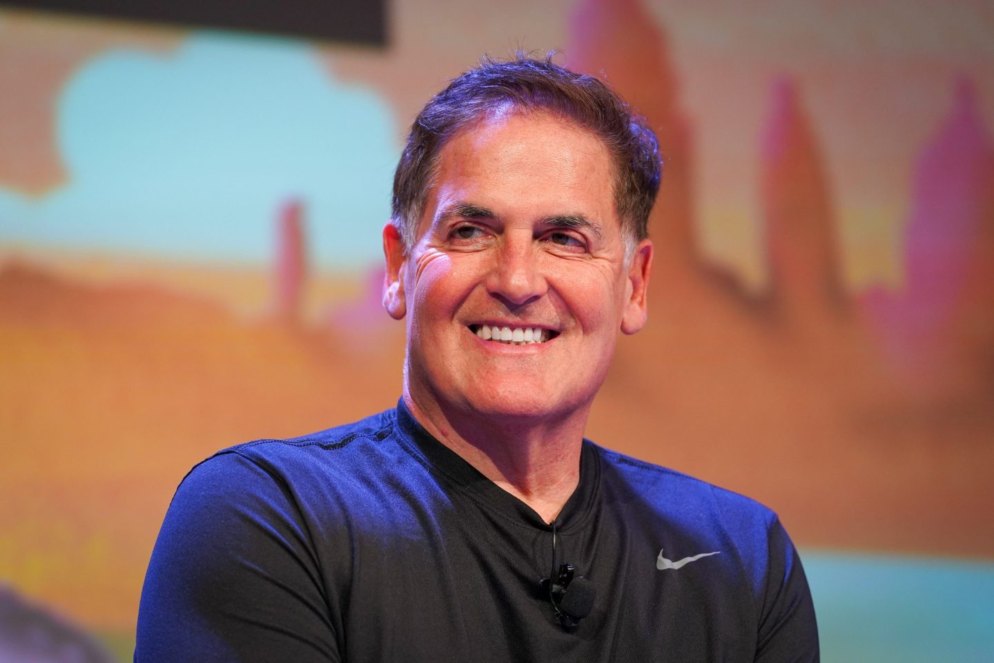 Mark Cuban smiles wearing a black Nike shirt.
