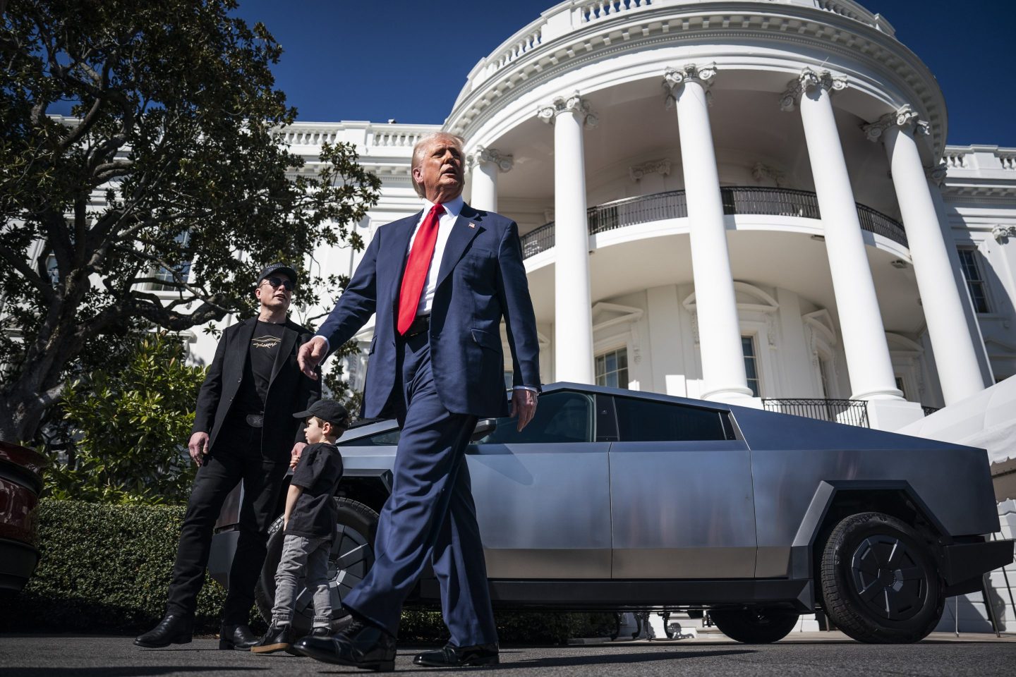 Donald Trump walks in front of a Tesla Cybertruck