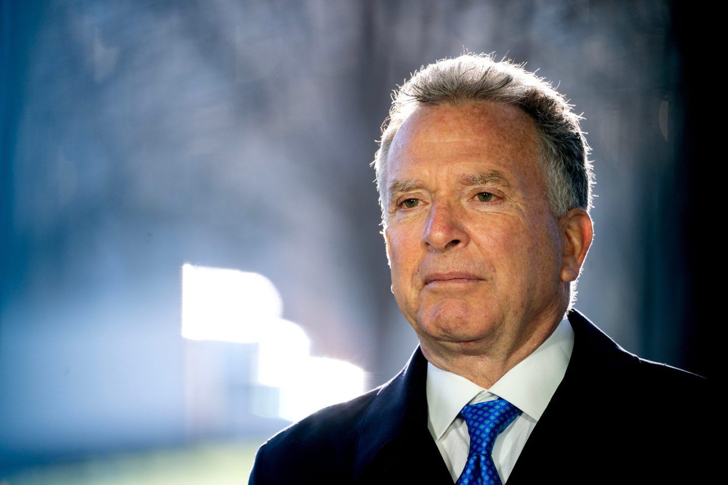 Steve Witkoff, wearing a suit, looks to the left while standing outside.