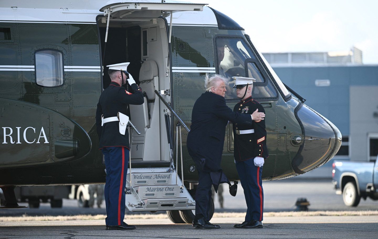 President Donald Trump greets a Marine as he steps off Marine One upon arrival at Morristown Municipal Airport, New Jersey, on Saturday.