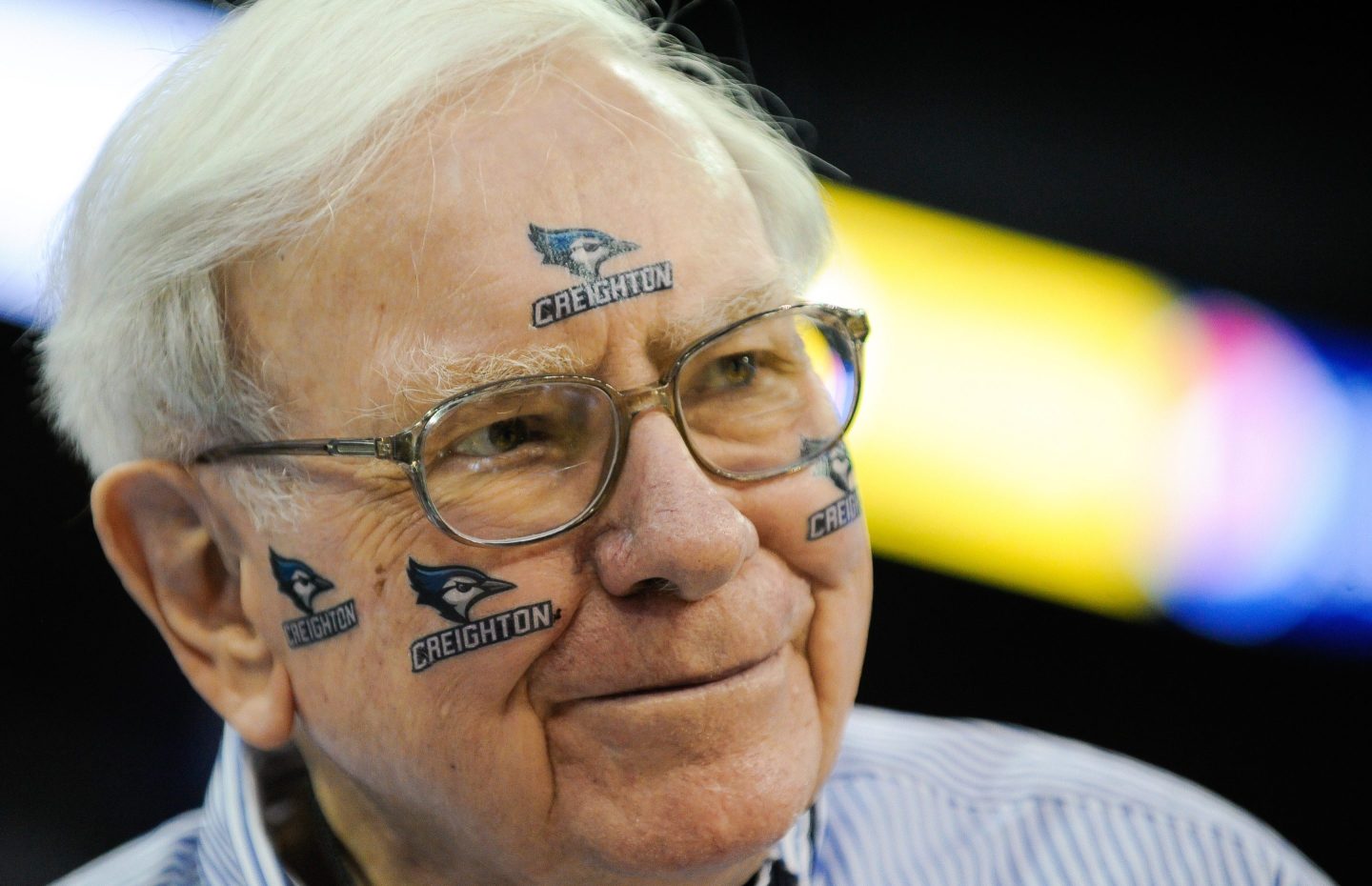 Warren Buffett wearing Creighton University stickers on his face.