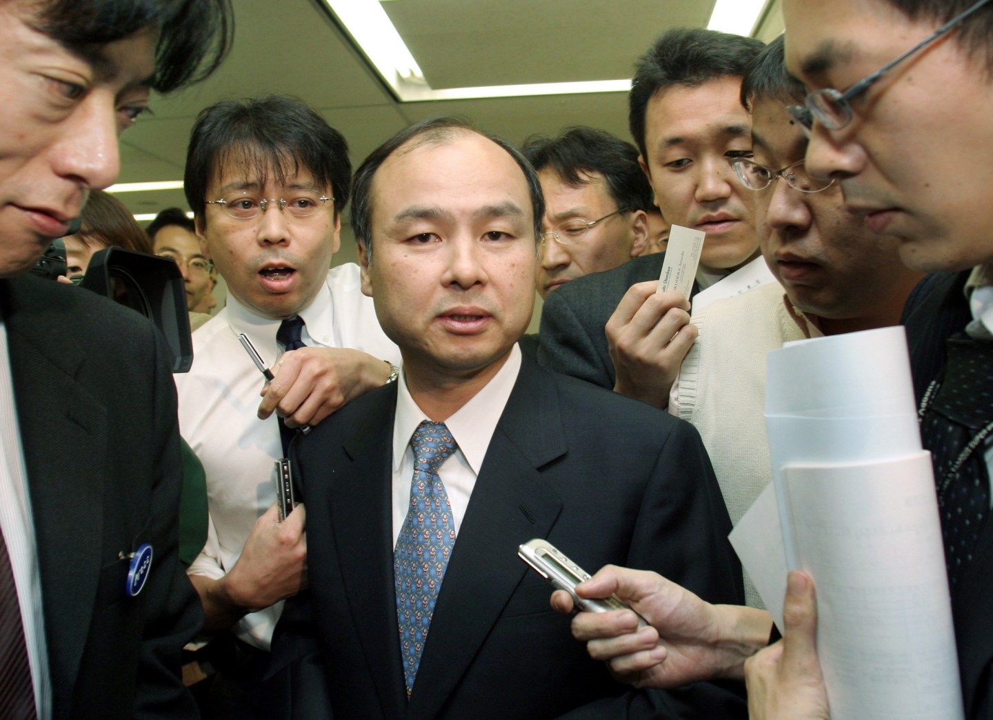 Masayoshi Son surrounded by reporters in 2004.
