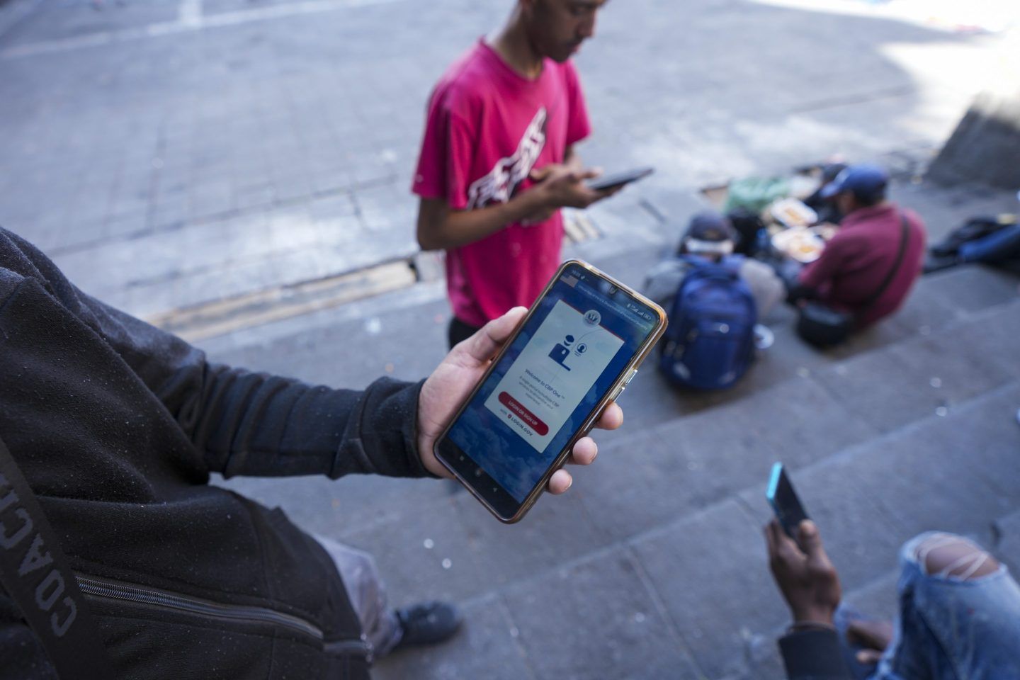 Venezuelan migrant Yender Romero shows the U.S. Customs and Border Protection (CBP) One app on his cell phone, which he said he used to apply for asylum in the U.S. and is waiting on an answer, at a migrant tent camp outside La Soledad church in Mexico City, Jan. 20, 2025.