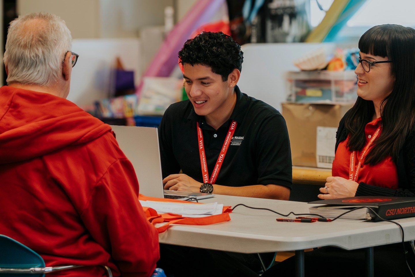 Two students help a man file his taxes