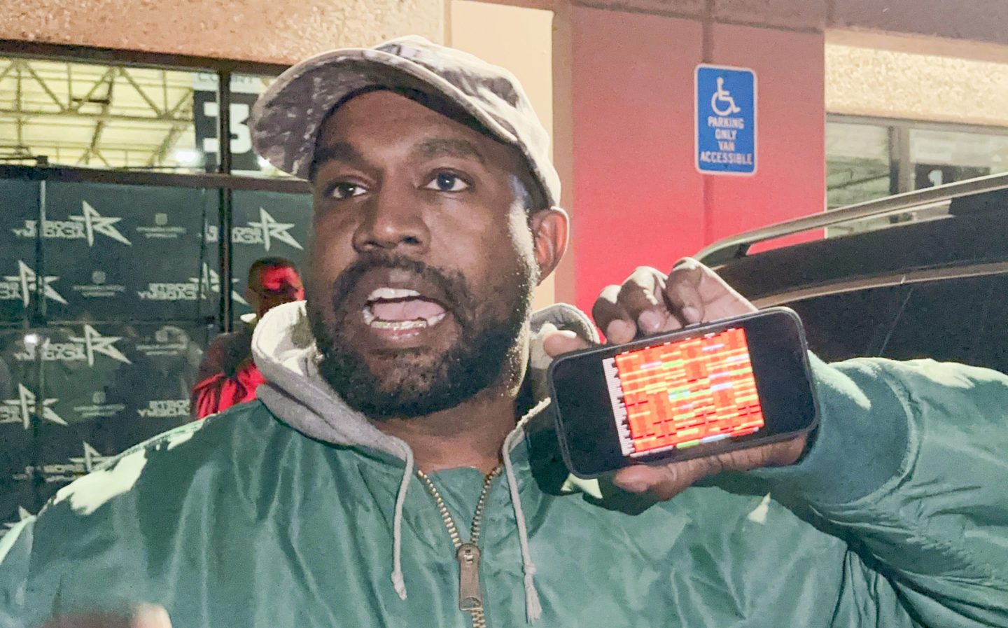 Ye aka Kanye West holds up a phone