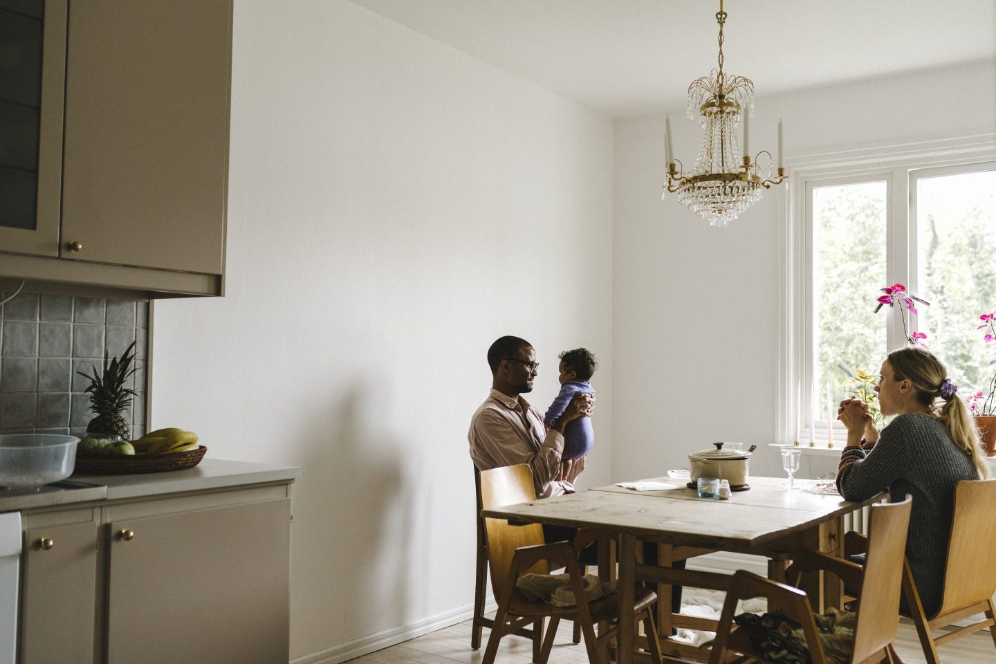 Two parents and a child sitting at a table having a meal together.