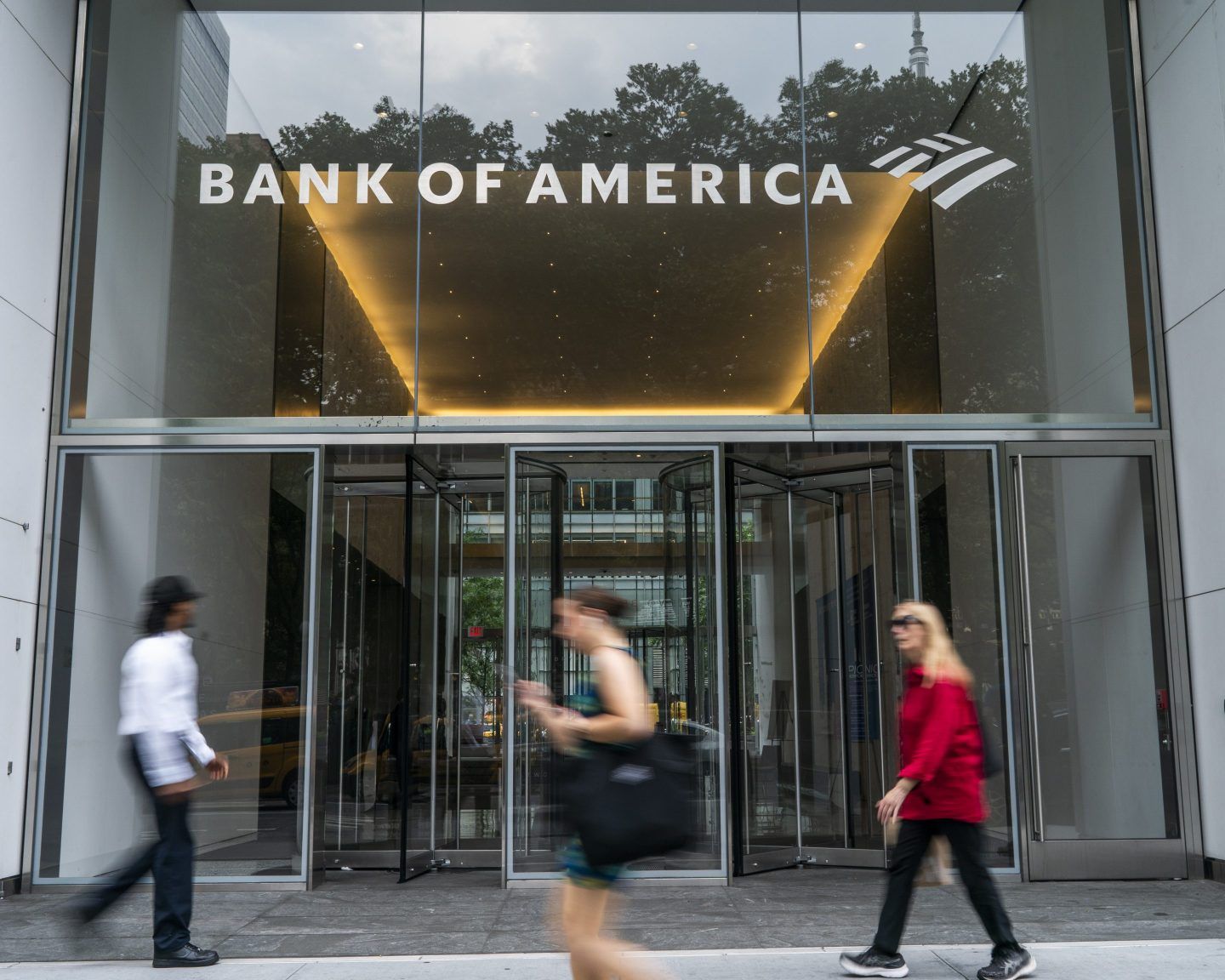 People walk in front of the Bank of America headquarters