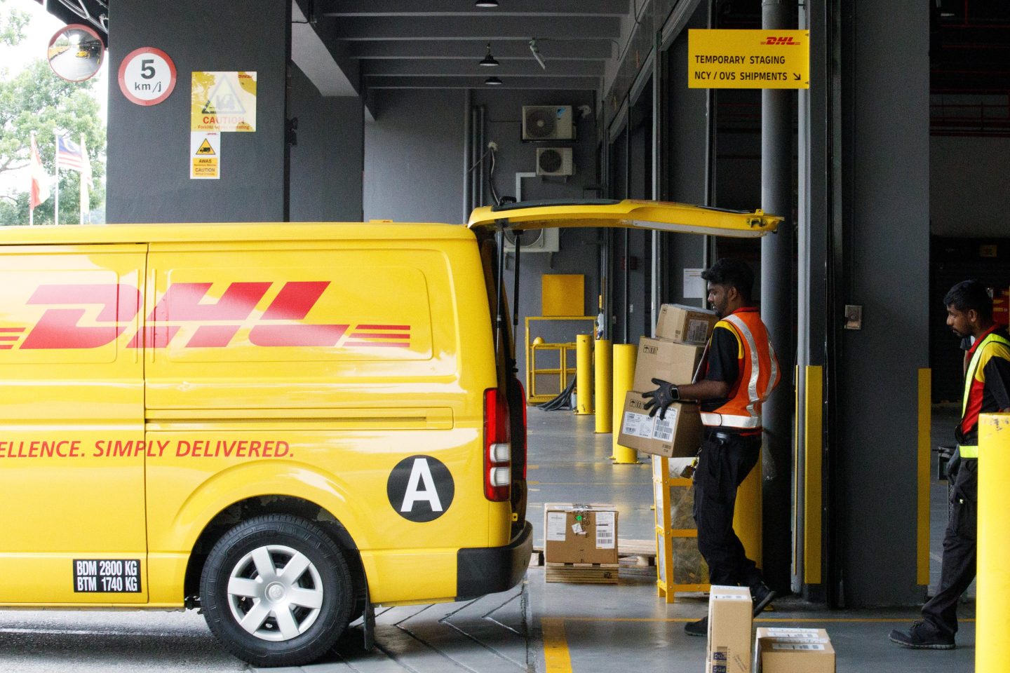 Delivery person loading a DHL van