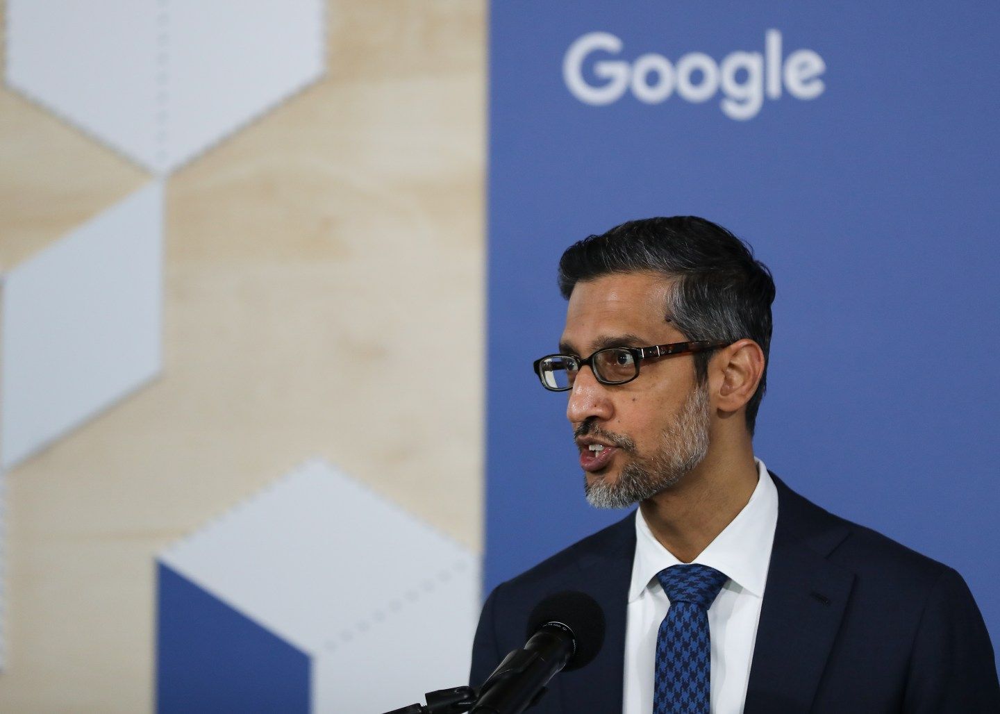 Sundar Pichai in front of a Google logo.