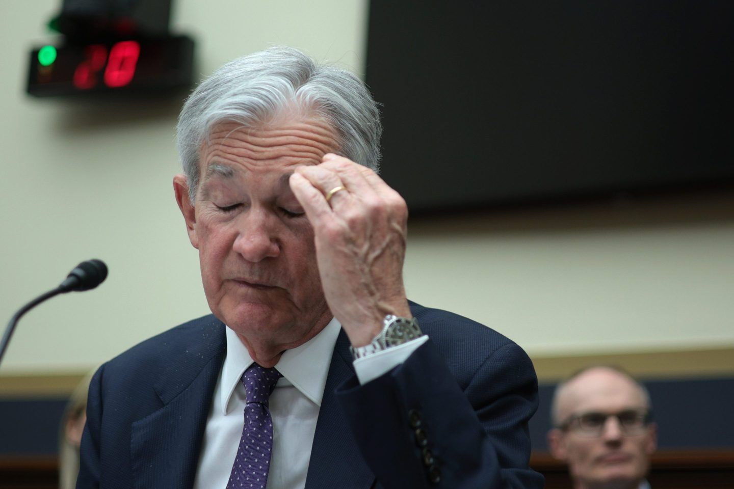 Jerome Powell puts his left hand to his head as he testifies before the House Committee on Financial Services.