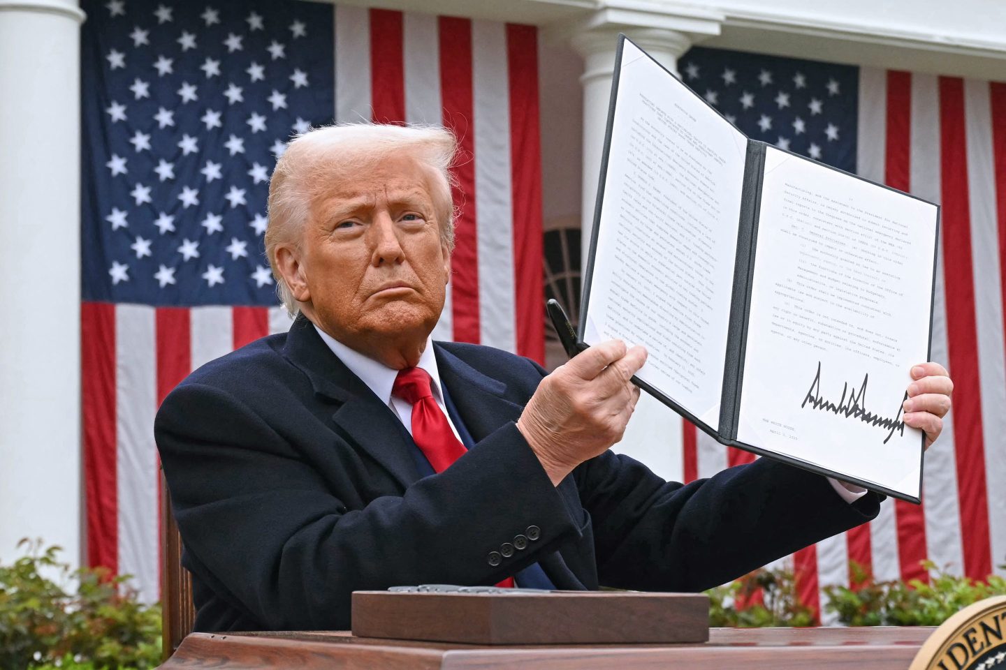 US President Donald Trump holds a signed executive order after delivering remarks on reciprocal tariffs during an event in the Rose Garden entitled "Make America Wealthy Again" at the White House in Washington, DC, on April 2, 2025.