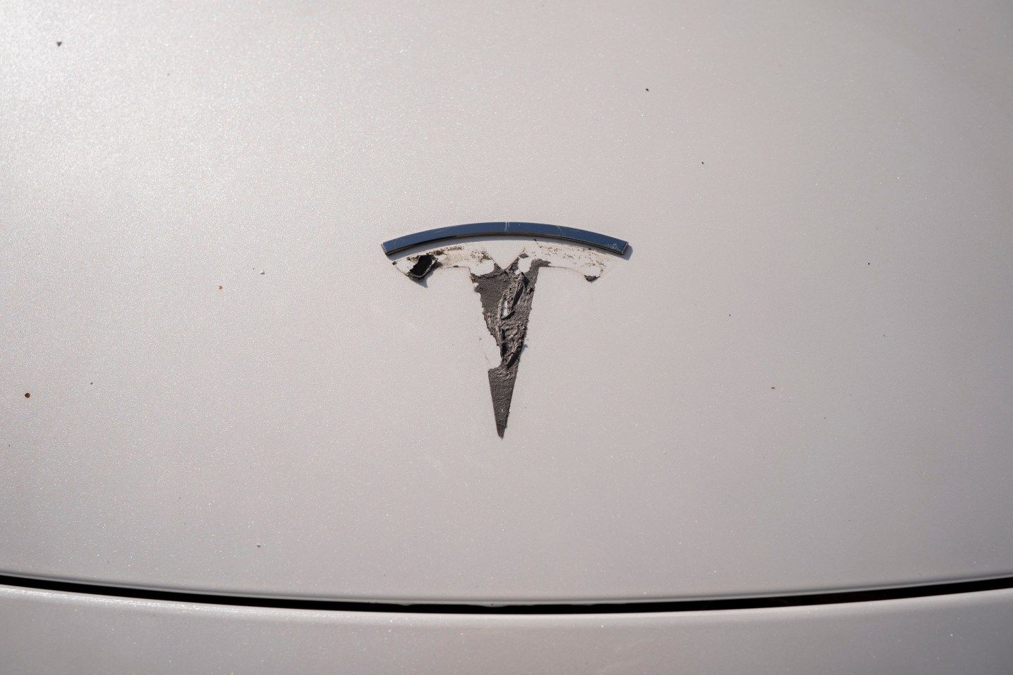 A Tesla emblem is being removed from a vehicle during a "de-badging" event on April 12, 2025 in Seattle, Washington. (Photo: David Ryder/Getty Images)