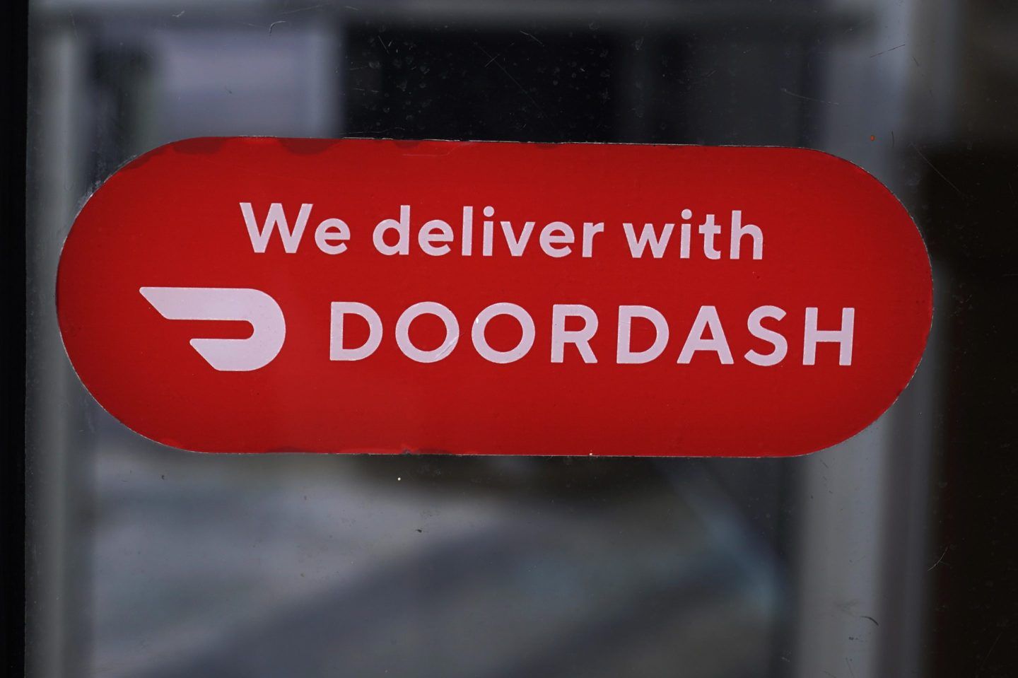A DoorDash sign on a Dunkin' Donuts