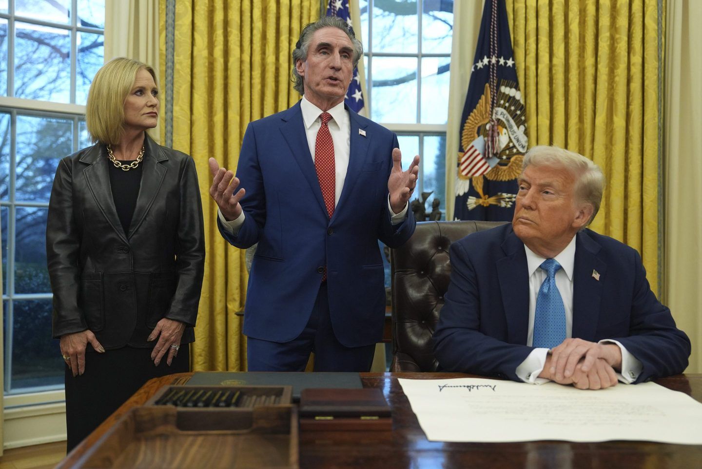 Interior Secretary Doug Burgum speaks as his wife, Kathryn, and President Donald Trump listen, in the Oval Office of the White House, on Jan. 31, 2025, in Washington.
