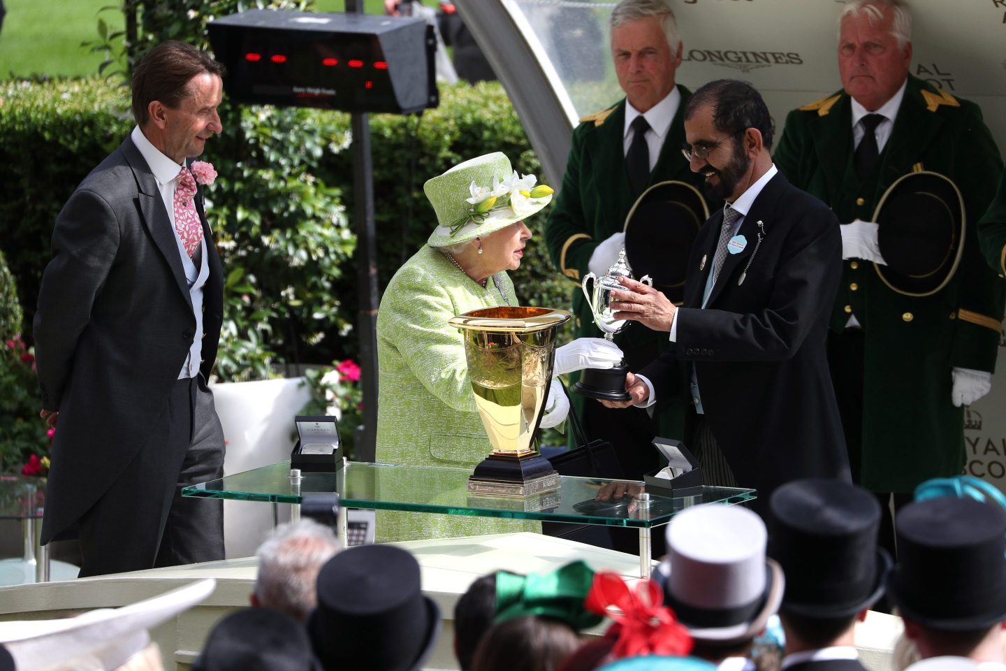 Queen Elizabeth II presents Godolphin founder Sheikh Mohammed bin Rashid Al Maktoum with a trophy during day five of Royal Ascot at Ascot Racecourse.