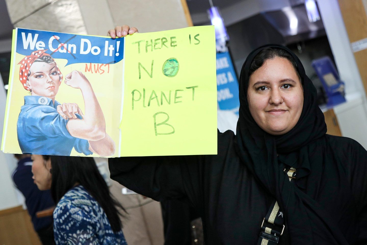 A woman holds up a sign during a demonstration in Qatar calling for a stand against climate change.