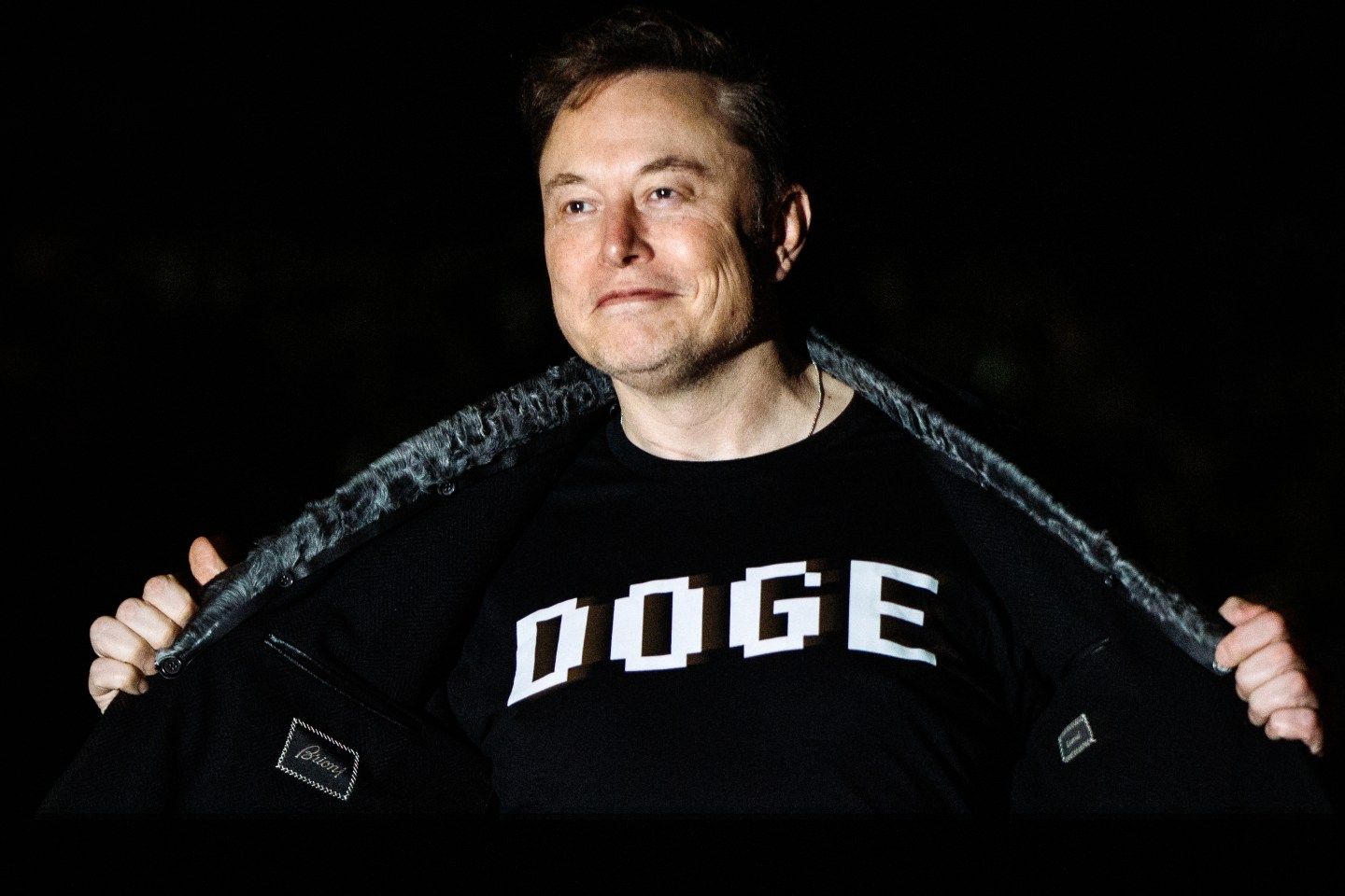 Elon Musk is wearing a DOGE t-shirt.
