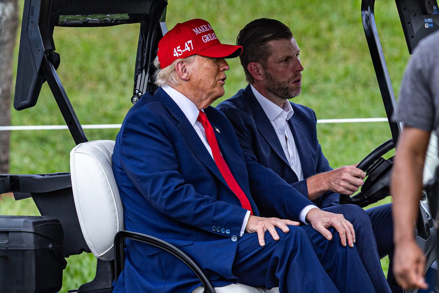 President Donald Trump and his son Eric Trump riding in a golf cart