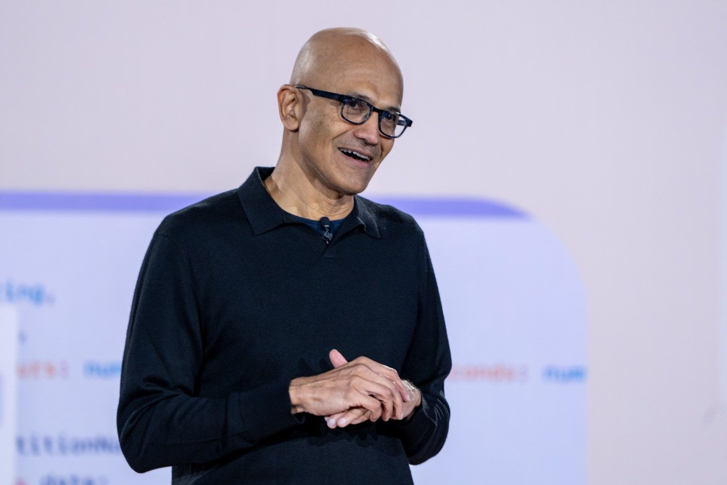 Satya Nadella appears on stage smiling.