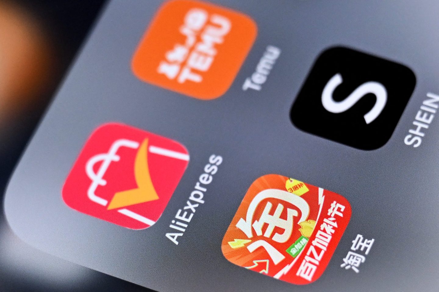 An illustration photo shows the logos of Chinese shopping app