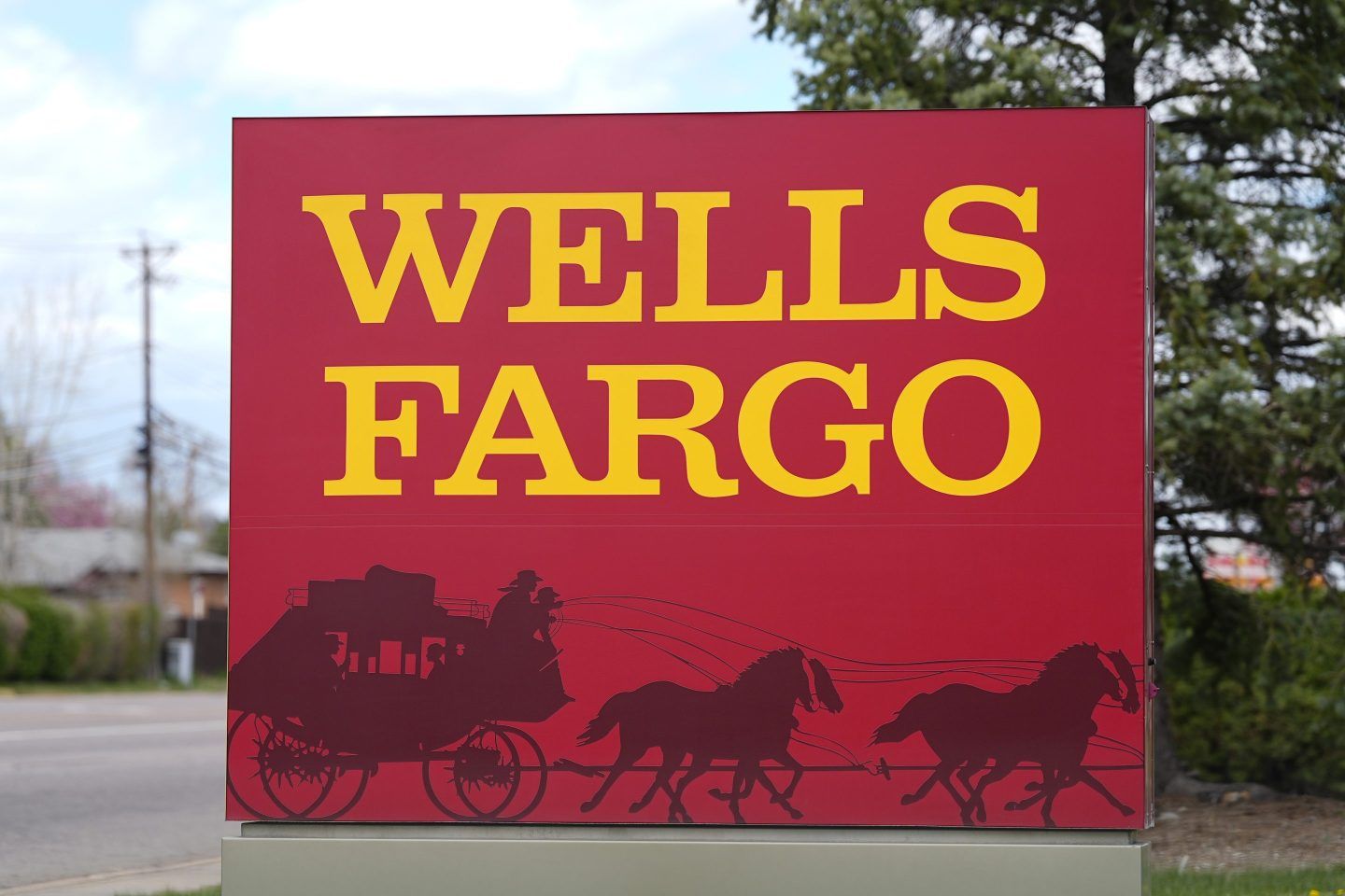 A sign stands outside a branch of Wells Fargo bank on April 17, 2024, in Littleton, Colo.