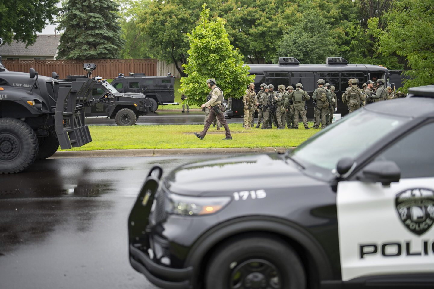 Law enforcement officers including local police, sheriffs and the FBI, stage less than a mile from a shooting in Brooklyn Park, Minn. on Saturday.