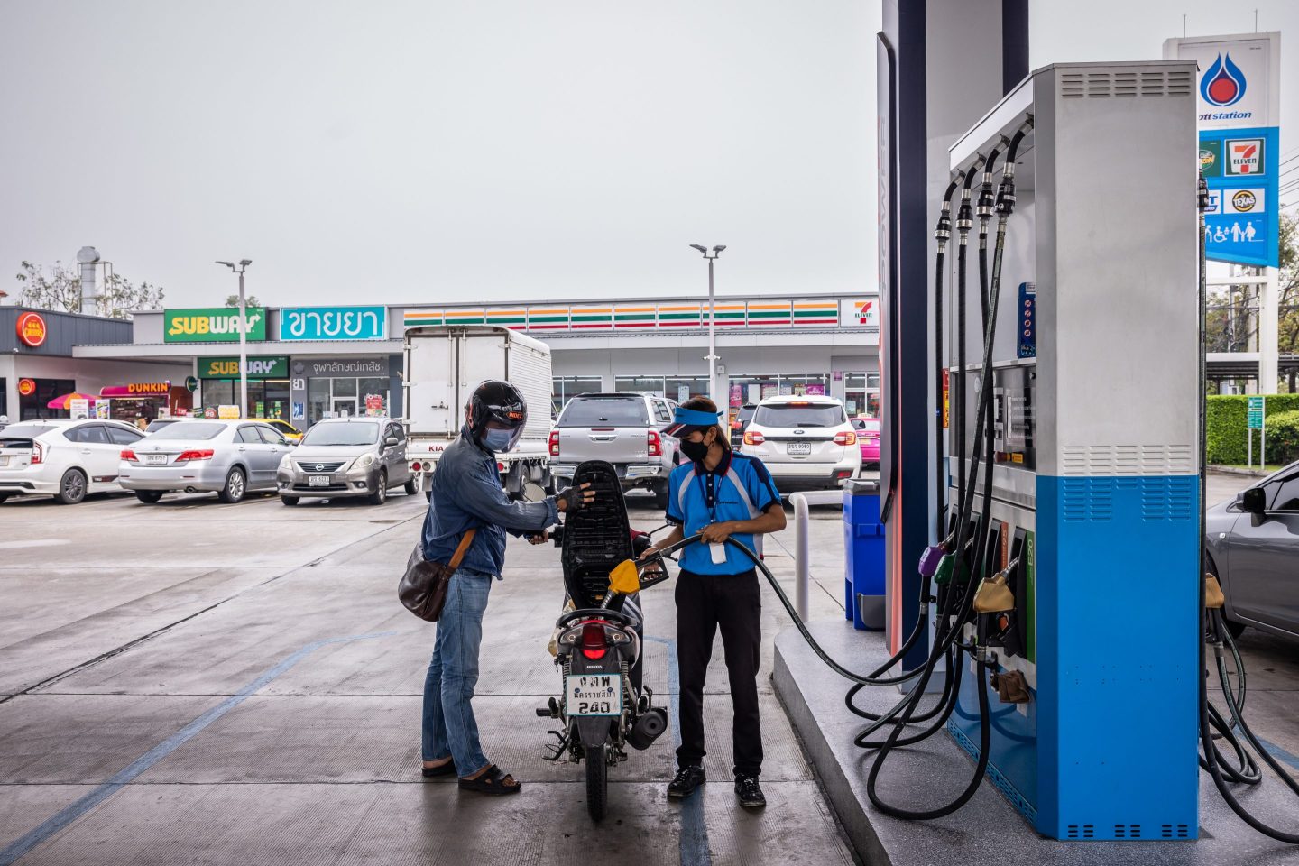An employee refuels a customer's motorcycle at a PTT gas station in Bangkok on Feb. 15, 2023. 