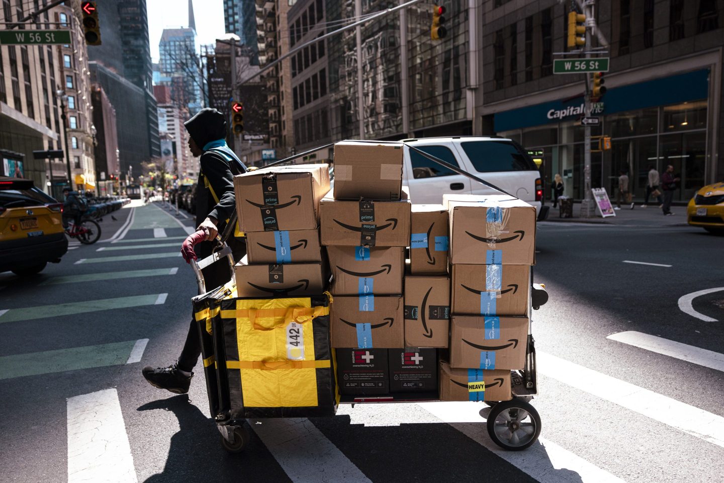 An Amazon contract worker pulls a cart of packages for delivery in New York, US, on Monday, April 22, 2024.