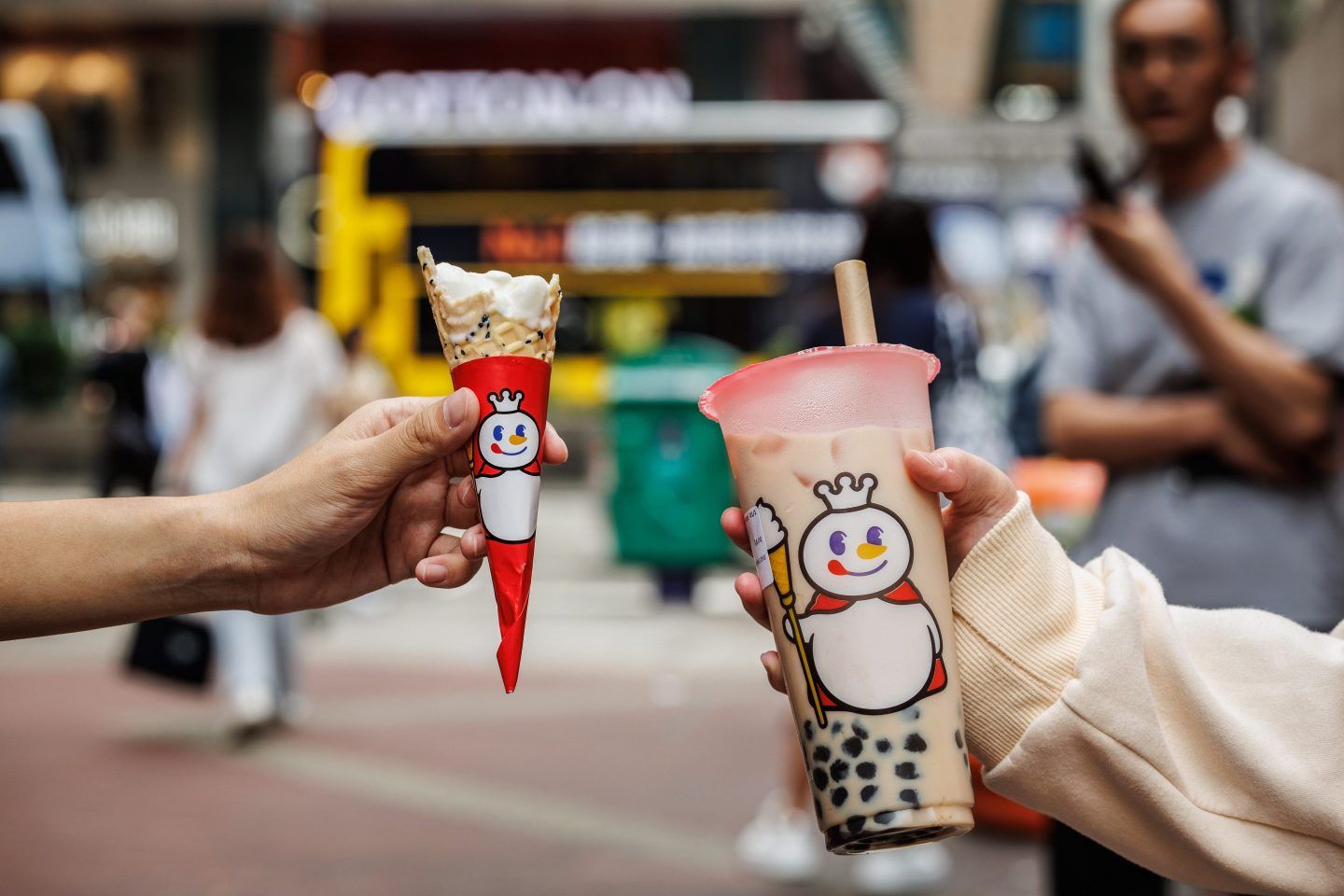 People holding an ice cream cone and boba tea from Mixue, the world's largest fast-food chain by number of store locations