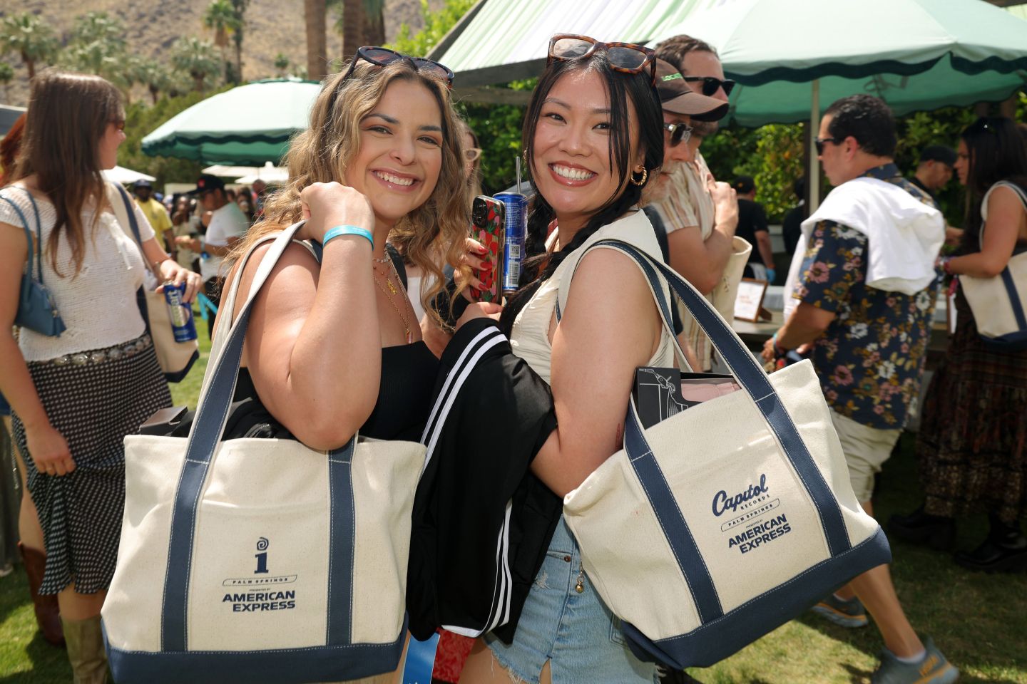 Young women carrying Amex tote bags at an event