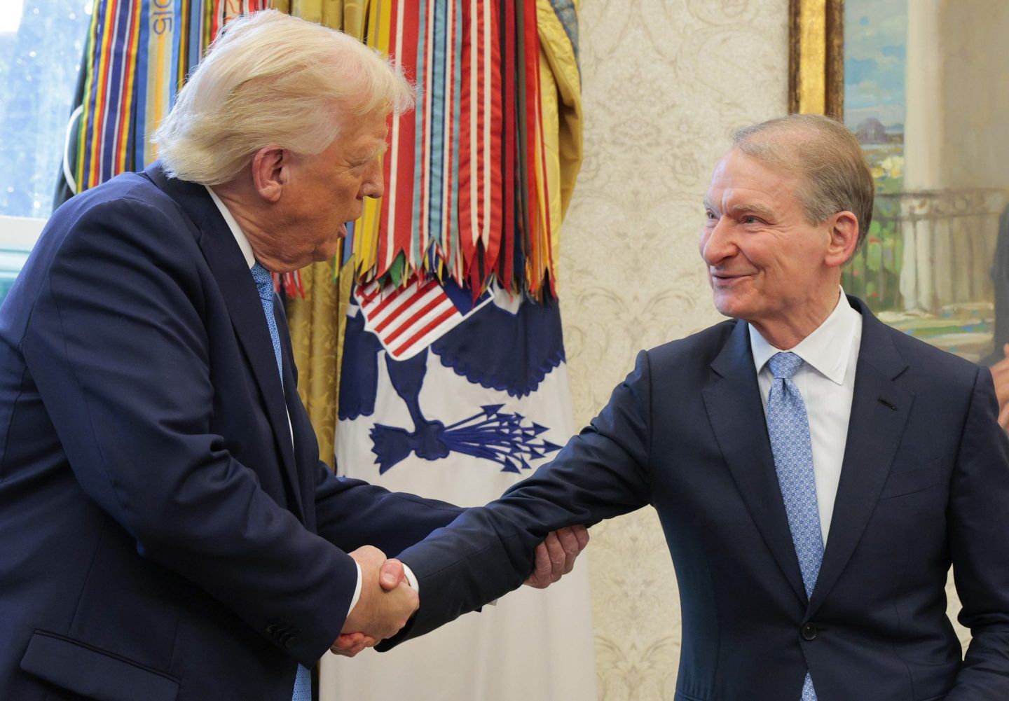 President Donald Trump shakes hands with Securities and Exchange Commission Chairman Paul Atkins during Atkins' swearing-in ceremony in the Oval Office at the White House on April 22, 2025 in Washington, DC.