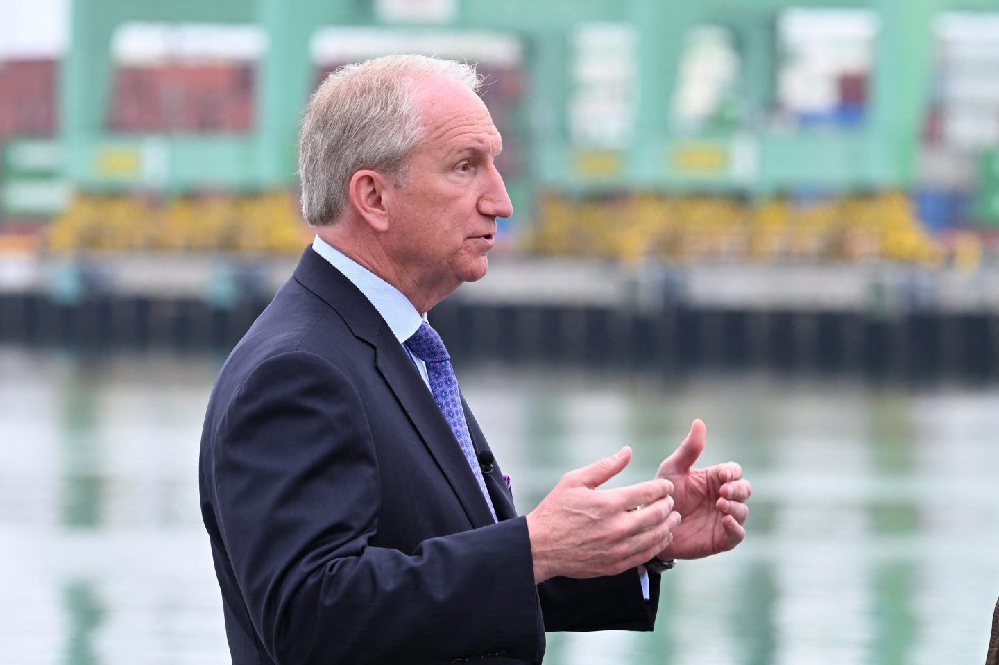 Gene Seroka stands in front of the Port of Los Angeles and looks to his left.