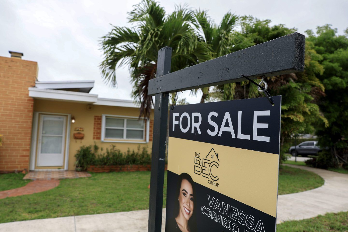 A “for sale” sign in front of a home in Miami on May 12. Economists are raising the possibility of a prolonged downturn in the housing market.