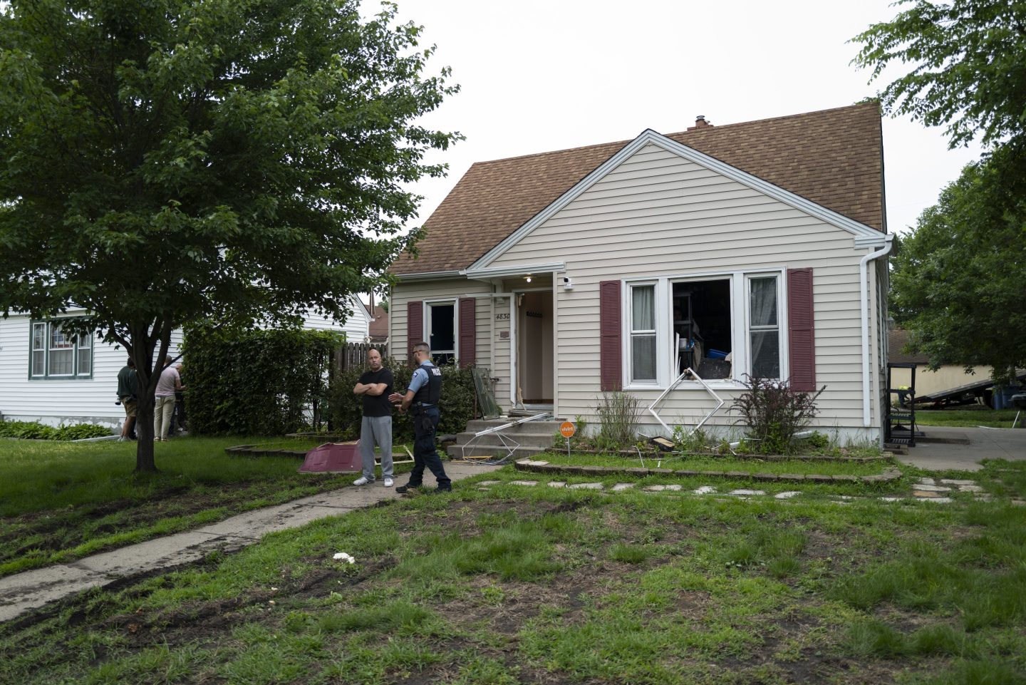 A Minneapolis police officer outside a home where Vance Boelter had stayed.