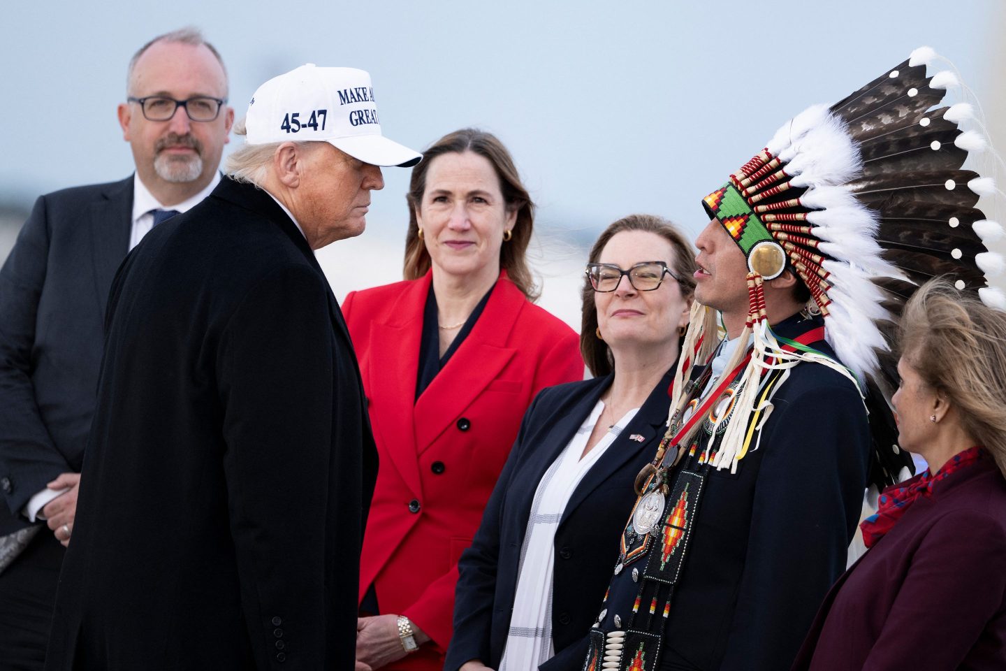 US President Donald Trump (2L) is greeted by Steven Crowchild of the Tsuut'ina First Nation (2R) and others upon arrival at Calgary International Airport, before the start of the G7 summit, in Calgary, Alberta, Canada, June 15, 2025.
