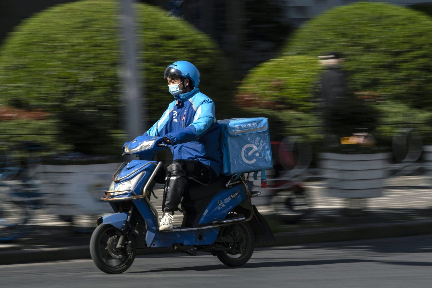 A delivery courier for Ele.me, Alibaba Group Holding Ltd.'s food-delivery platform, travels along a road in Shanghai, China, on Monday, March 22, 2021.
