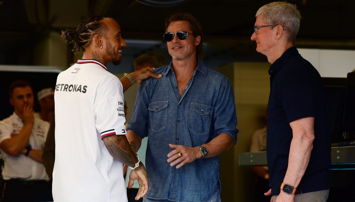 Lewis Hamilton, Brad Pitt, and Tim Cook huddle