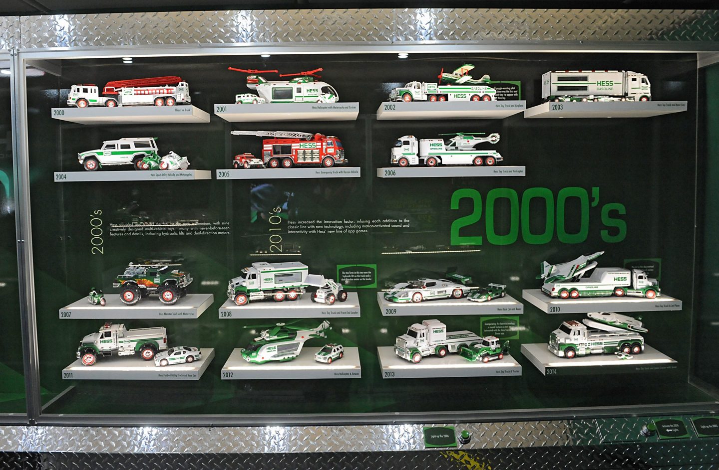 A glass case filled with Hess toy trucks