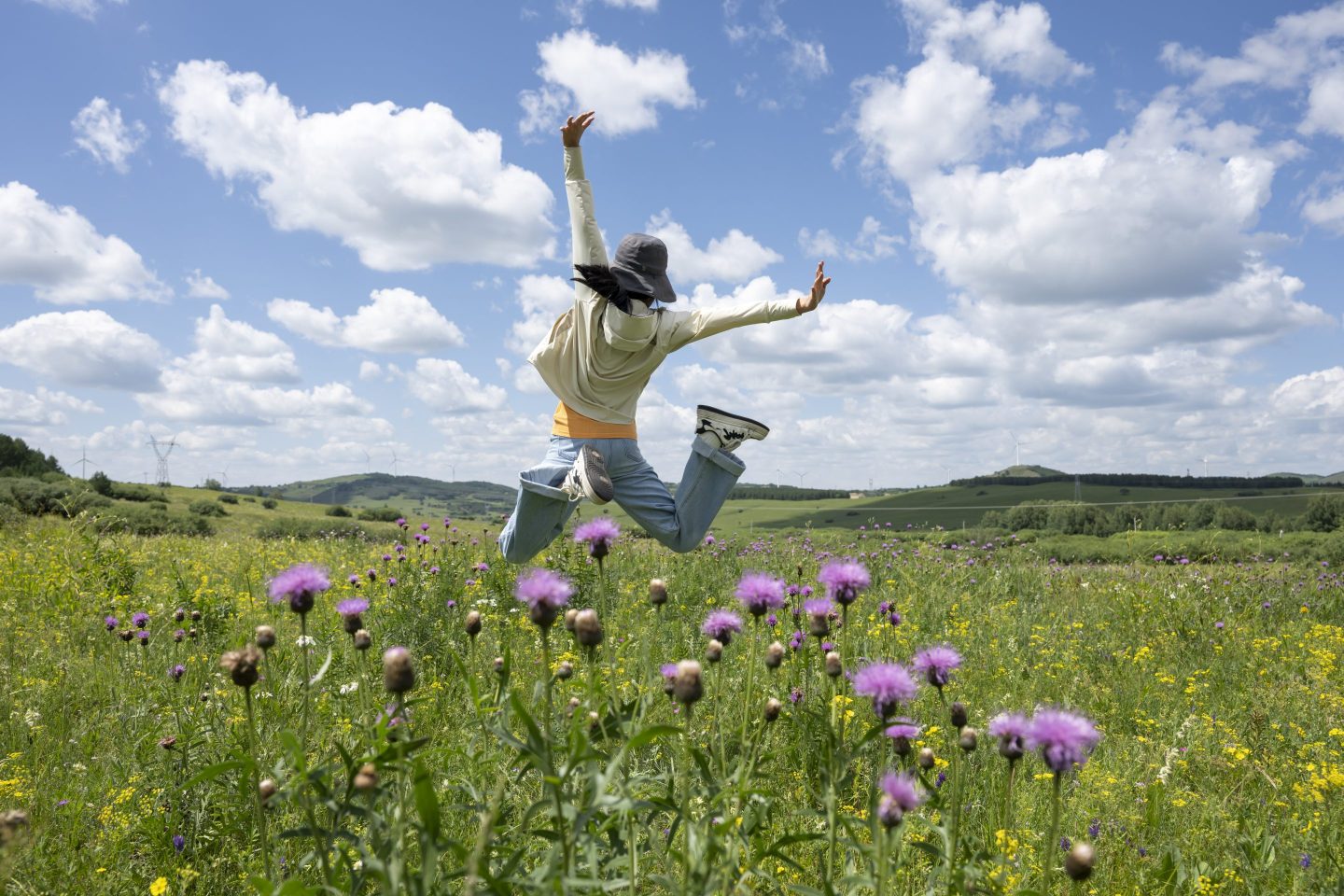Girl jumping in a field of flowers