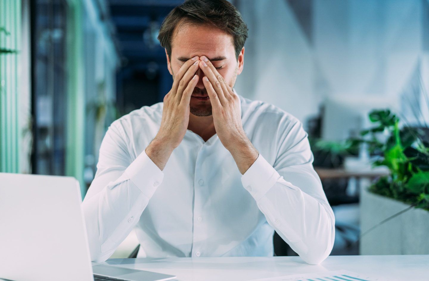Man at desk with his face in his hands