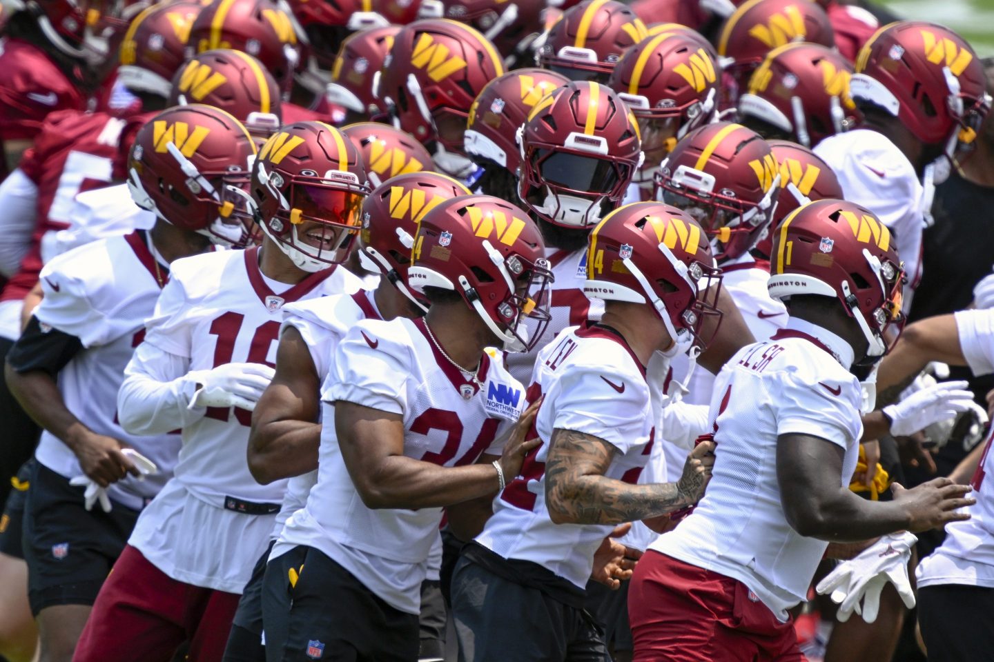 Washington Commanders players run through a gauntlet to start day two of mini camp in Ashburn, VA on June 11.