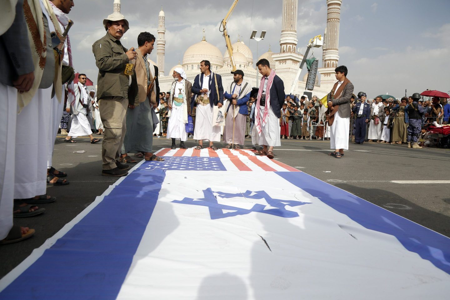 Yemenis prepare flags of US and Israel to be burnt during a demonstration against Israel's wars with Iran and Gaza on June 20, 2025 in Sana'a, Yemen.